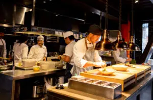 Chef preparing dishes in a busy restaurant kitchen.